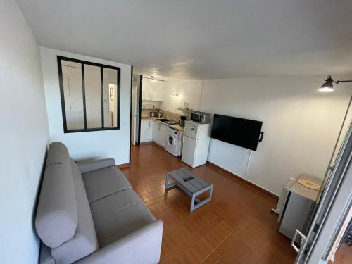 uma sala de estar com um sofá e uma cozinha em Appartement Studio cap d'agde avec vue port et piscine em Cap d'Agde