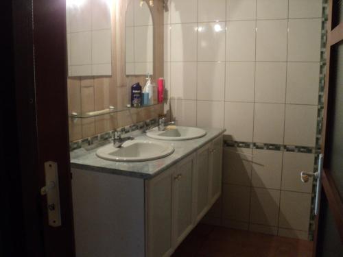 Un baño con dos lavabos y un espejo. en maison à la campagne, en Villedoux