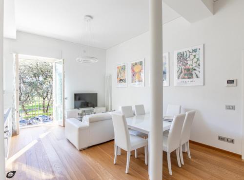 Elena House Apartments في فياريجيو: غرفة طعام بيضاء مع طاولة بيضاء وكراسي