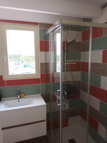 une salle de bain avec une douche et un lavabo et une fenêtre dans l'établissement appt avec magnifique vue sur le port, à Meschers-sur-Gironde