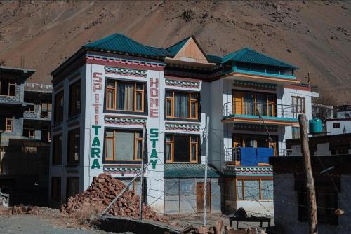 a house under construction in front of a mountain at SpitiTara Homestay in Kaza