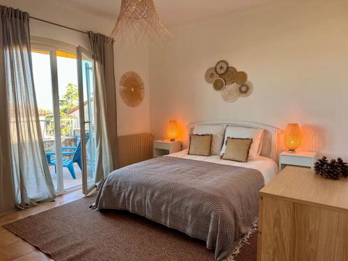 une chambre avec un lit et une grande fenêtre dans l'établissement Villa Lou Carou - Vue mer et Baie de Nice, à Cagnes-sur-Mer