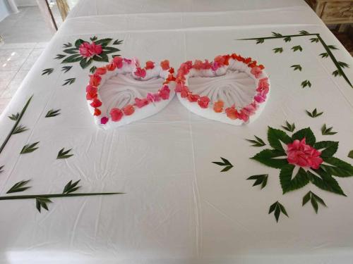 a white table with two heart shaped cakes on it at Bintang Tiga Bungalows Gili Air in Gili Air