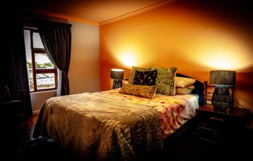 a bedroom with a bed with pillows and a window at The Green Door Cottage in Roodepoort