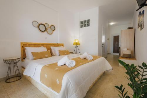 a bedroom with a large bed with towels on it at Studios Eliza in Livadion