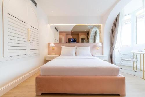 1 dormitorio con 1 cama blanca grande y espejo en Buldero Boutique, en Budva