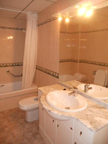a bathroom with a sink and a toilet and a shower at Apartamentos Palas Salou in Salou