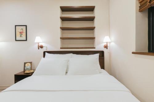 a bedroom with a white bed and a staircase at Lily Hidden Homestay in Hanoi