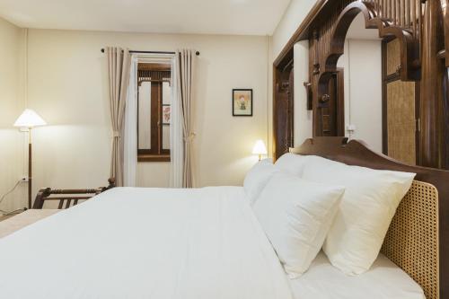 a bedroom with a large bed with white pillows at Lily Hidden Homestay in Hanoi