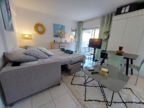 un salon avec un lit et une table dans l'établissement Studio Montrose Cannes - Axelle Loc'Appart, à Cannes