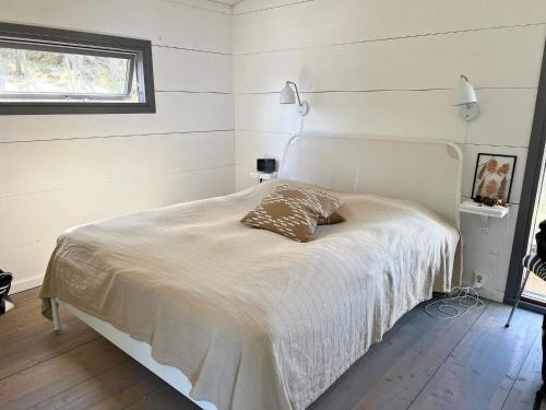 a bedroom with a bed with a white blanket and a window at 7 person holiday home in JÄRNA in Järna
