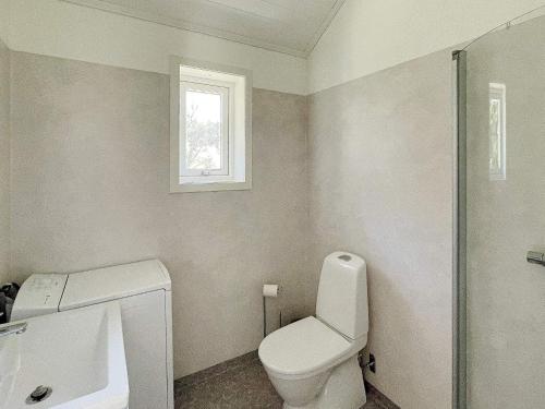 a bathroom with a toilet and a sink and a window at 4 star holiday home in LJUSTERÖ in Norra Ljustero