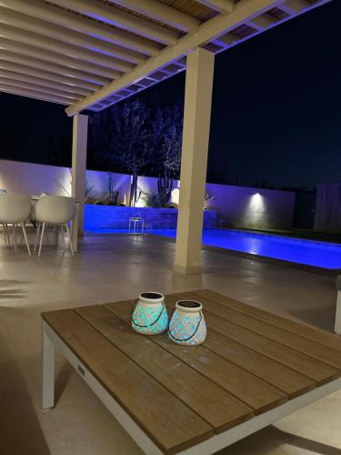 Villa Nawel Piscine privée et chauffée sans vis-à-vis في أغادير: مزهريتين جالسين على طاولة خشبية في غرفة