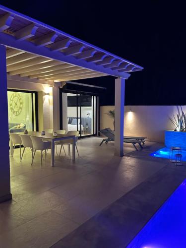 Villa Nawel Piscine privée et chauffée sans vis-à-vis في أغادير: فناء مع طاولة وكراسي واضاءة زرقاء