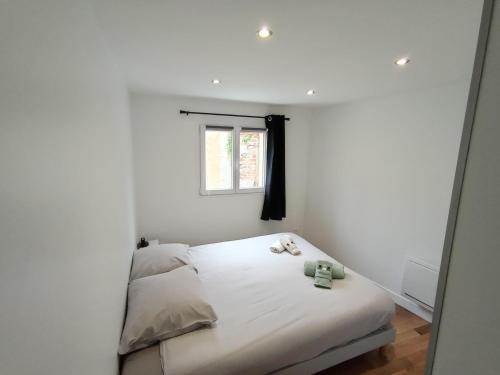 una piccola camera da letto con un letto bianco e una finestra di 6 personnes / Proche Disney et aéroport CDG a Annet-sur-Marne