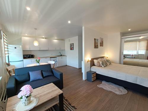 a living room with a bed and a couch at Sea Sand apartment in Liepāja