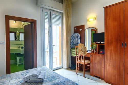 Dormitorio con cama, escritorio y TV en Hotel Euro, en Bellaria-Igea Marina