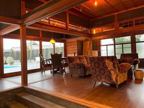 ein Wohnzimmer mit Stühlen, einem Tisch und Fenstern in der Unterkunft Awajishima dog stay,YAGI - Vacation STAY 93054v in Minamiawaji