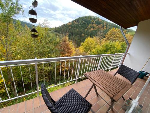 un porche con 2 sillas y una mesa de madera en el balcón en Waldhaus Max, en Bad Wildbad