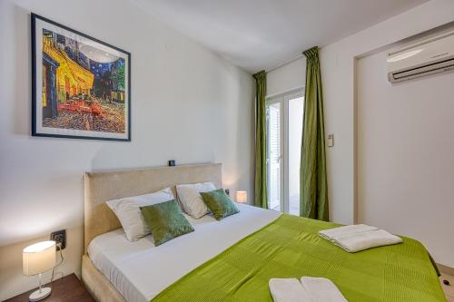 - une chambre avec un grand lit et une couverture verte dans l'établissement Portalbona Apartments - Apartment 6, à Rabac