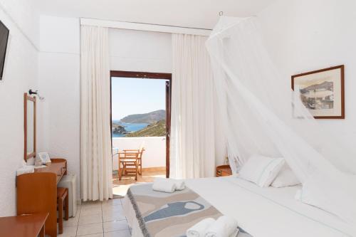 a bedroom with a bed and a view of the ocean at Golden Sun Hotel Patmos in Patmos
