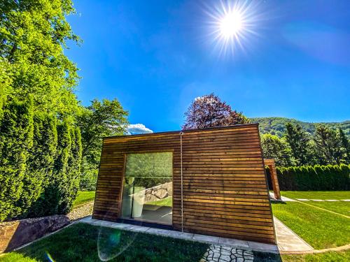 a small house in a garden with the sun overhead at Luxusvilla Österreich in Scheibbs