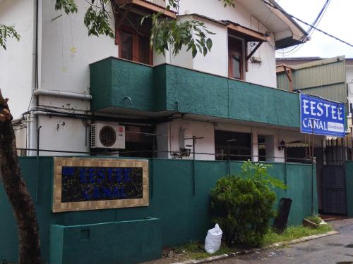 a building with a green fence in front of it at EESTEE Canal in Colombo