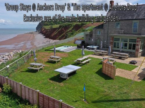 a park with benches and picnic tables and the beach at Anchor's Drop in Blue Anchor