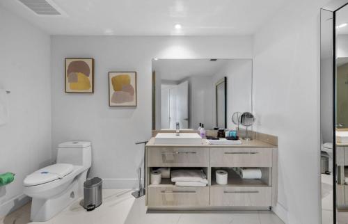 a bathroom with a sink and a toilet and a mirror at Hyde Resort Oceanview Luxurious 2-Bedroom PH 6Pax in Hollywood
