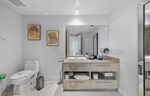 a bathroom with a sink and a toilet and a mirror at Lyfe Oceanview Resort Luxury 2 Bedroom Unit in Hollywood