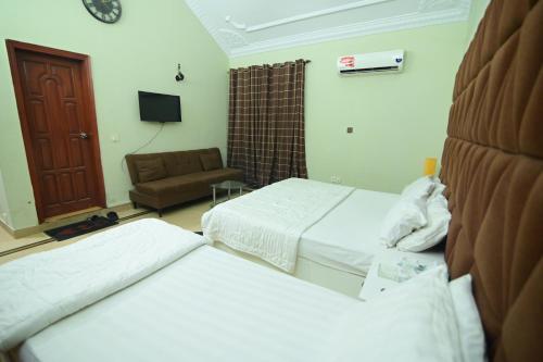a hotel room with two beds and a couch at SEAVIEW COTTAGE in Karachi