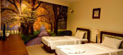 a room with two beds and a painting on the wall at Sea Star House in Ao Nang Beach
