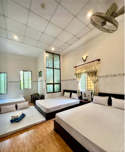 a bedroom with two beds and a ceiling at Nam Đô Hotel Cần Thơ Downtown in Can Tho