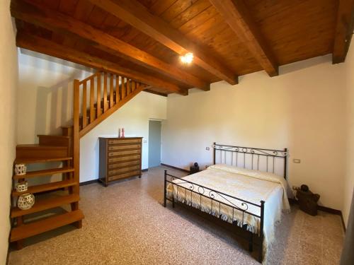 a bedroom with a bed and a wooden staircase at Colle Costanza in Todi