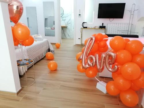 a room with orange balloons and a room with a bed at Appartamenti Mascagni in Sannicandro di Bari