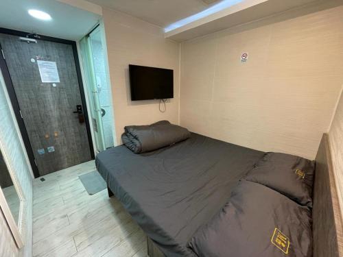 a bedroom with a bed and a flat screen tv at 榆樂旅館 YULOK Guesthouse in Hong Kong