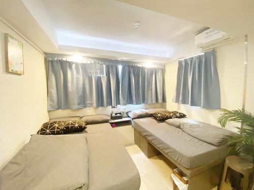 a room with two beds in front of a window at 榆樂旅館 YULOK Guesthouse in Hong Kong