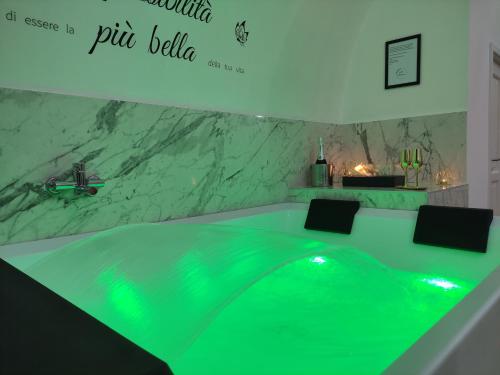 a green tub in a bathroom with a marble wall at Appartamenti Mascagni in Sannicandro di Bari