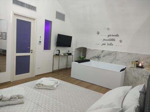 a white room with a bed and a tv at Appartamenti Mascagni in Sannicandro di Bari