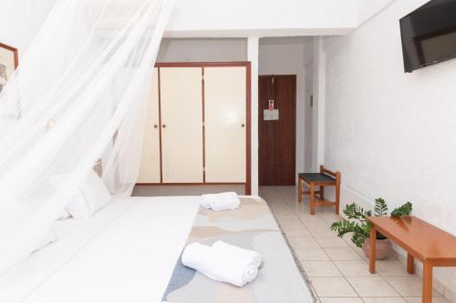 una camera d'albergo con letto e scrivania di Golden Sun Hotel Patmos a Patmo (Patmos)