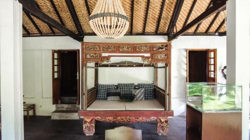 a living room with a couch and a chandelier at Ohmmstay - Rumah Pendopo in Tanjungtirto