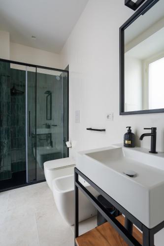 a white bathroom with a sink and a mirror at Weaver Suites By Dimorra in Naples