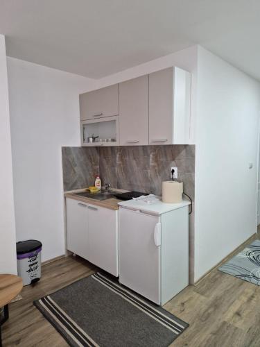a kitchen with white cabinets and a counter top at Apartman Nena Užice 2 in Užice