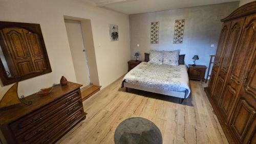 - une chambre avec un lit et une commode en bois dans l'établissement Le Zell, à Zellenberg