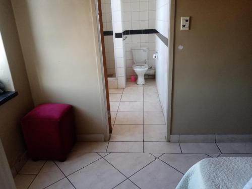 baño pequeño con aseo y puerta en Ebony Lounge Hotel and Event Center en Pretoria