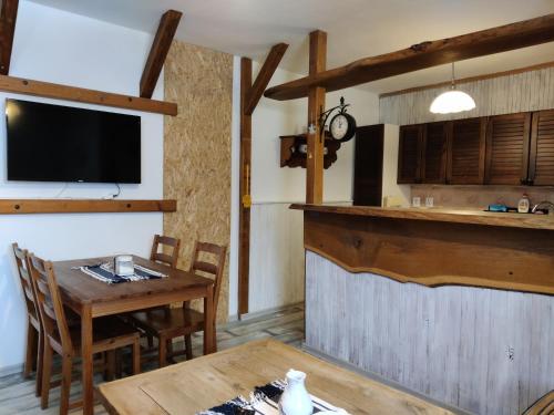 a kitchen and dining room with a table and a tv at Penzion u Lupíků in Frýdlant nad Ostravicí