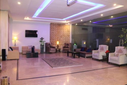 un vestíbulo con sofás y sillas en un edificio en Beverly Inn Hotel, en Lahore