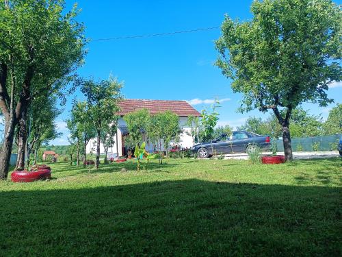 a yard with trees and a house and a car at Apartman Cirkic in Sanski most