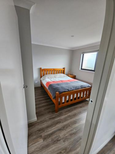 Schlafzimmer mit einem Bett und einem Fenster in der Unterkunft Brand new self-contained one bedroom unit in Queanbeyan