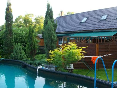 a house with a swimming pool in front of a house at Penzion u Lupíků in Frýdlant nad Ostravicí